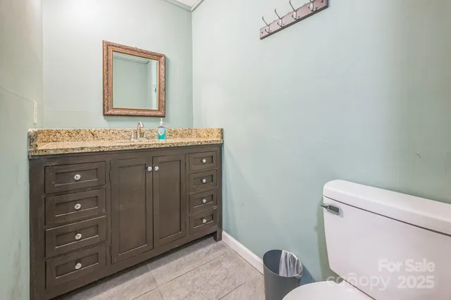 a bathroom with a toilet sink vanity and mirror