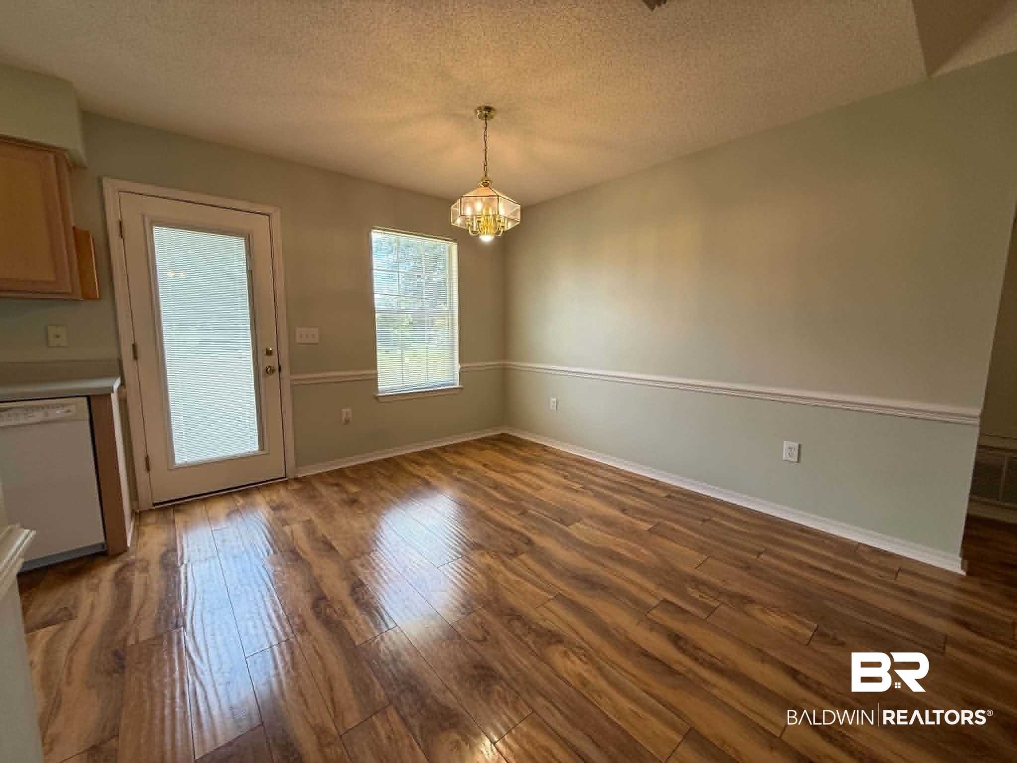 123 Pennbrooke Loop Foley, AL 36535 - Photo 19 of 49 Spacious dining area featuring wood-finish flooring, a decorative chandelier, and chair rail molding