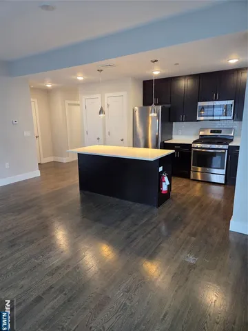 a large kitchen with stainless steel appliances a large counter top