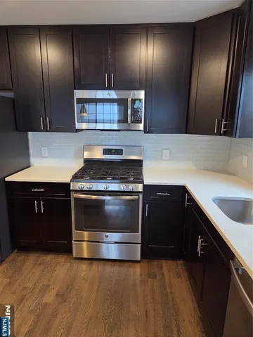 a kitchen with granite countertop stainless steel appliances and wooden cabinets