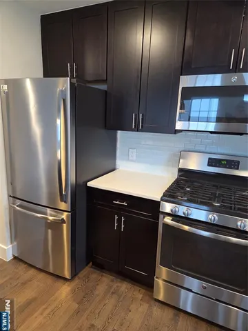a kitchen with granite countertop stainless steel appliances and wooden cabinets