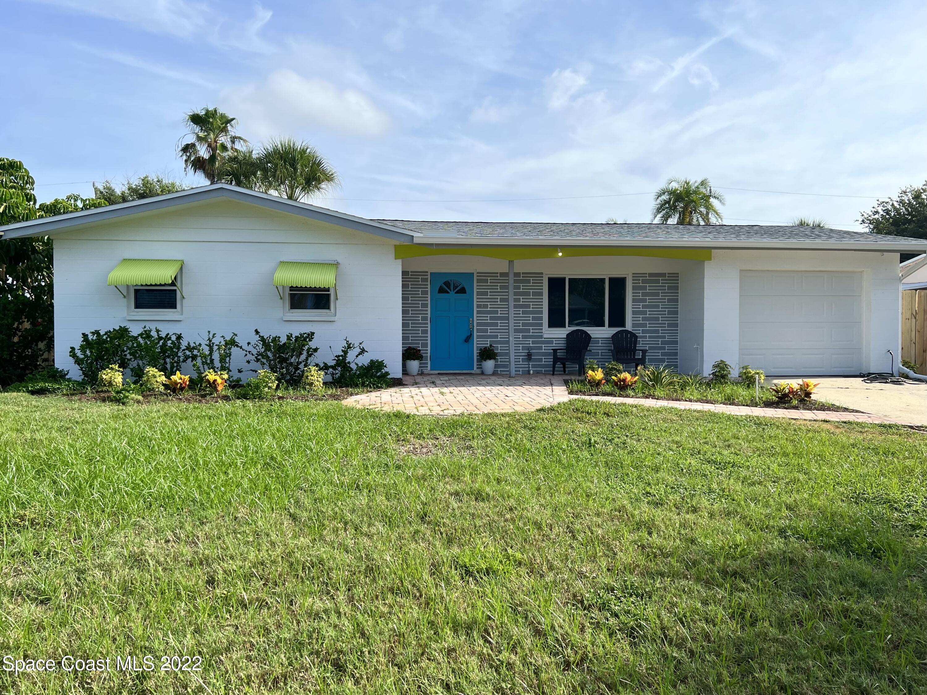 a front view of house with yard and outdoor seating