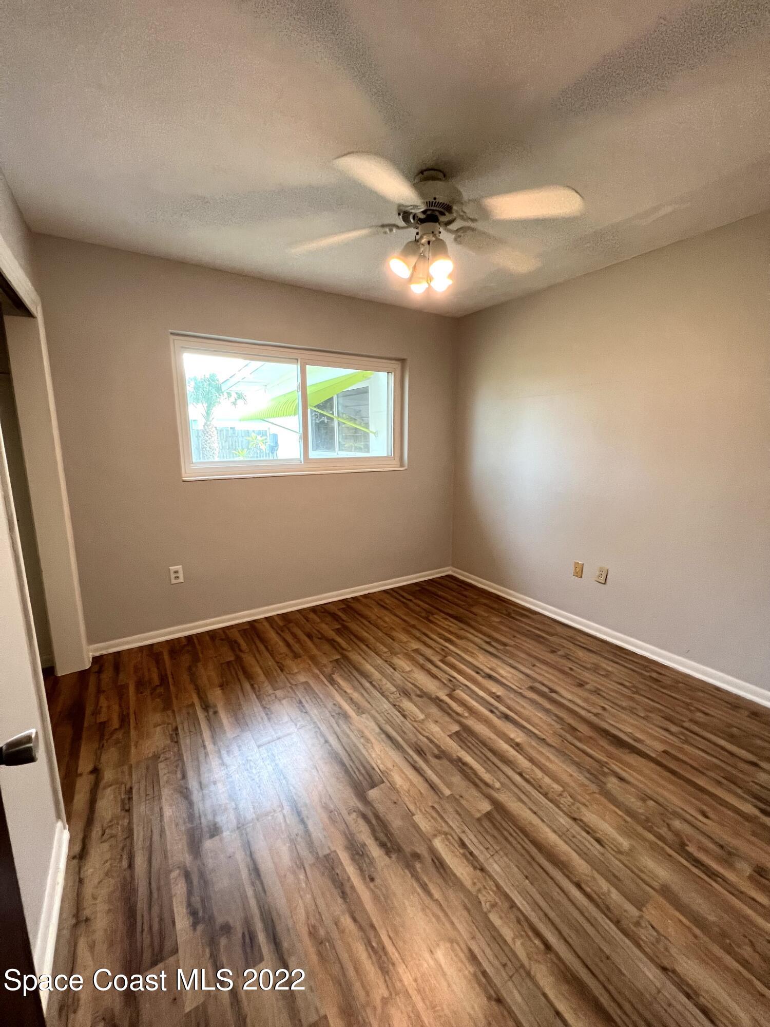 282 Fay Drive Indialantic, FL 32903 - Photo 21 of 27 an empty room with wooden floor and windows