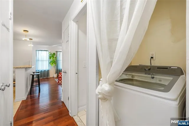 a view of a hallway with wooden floor and furniture