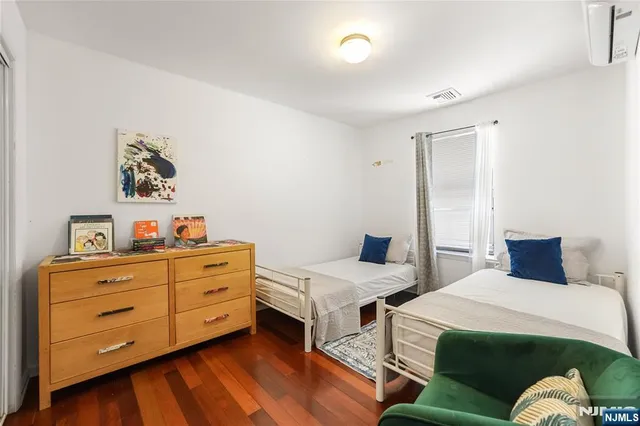 a bedroom with two beds and a dresser