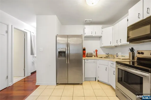 a kitchen with stainless steel appliances granite countertop a refrigerator sink and stove