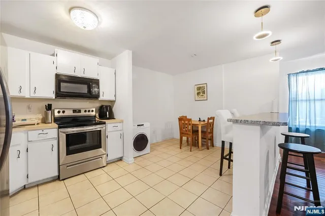 a kitchen with granite countertop a stove a sink and a microwave