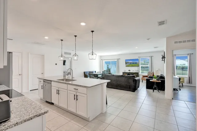 a view of a kitchen with kitchen island granite countertop lots of counter top and sink