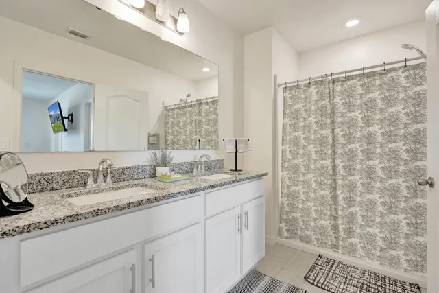 a bathroom with a granite countertop sink a mirror and a shower