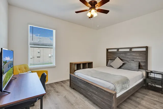 a bedroom with a bed a desk and chair