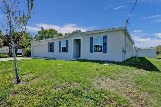 a view of a house with backyard and garden