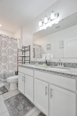 a bathroom with a granite countertop sink mirror and toilet