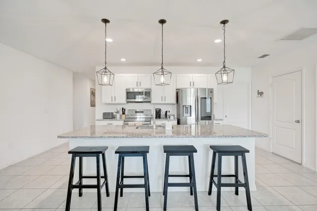 a kitchen with kitchen island granite countertop a table and chairs in it