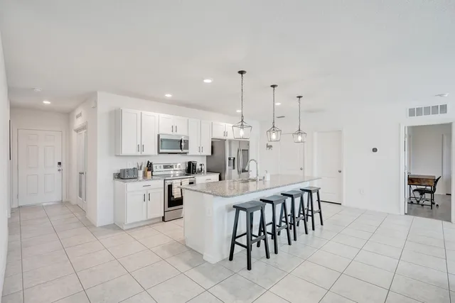 a kitchen with white cabinets and stainless steel appliances