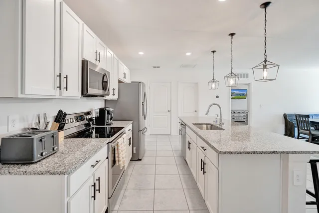 a kitchen with stainless steel appliances granite countertop a sink a stove and a refrigerator