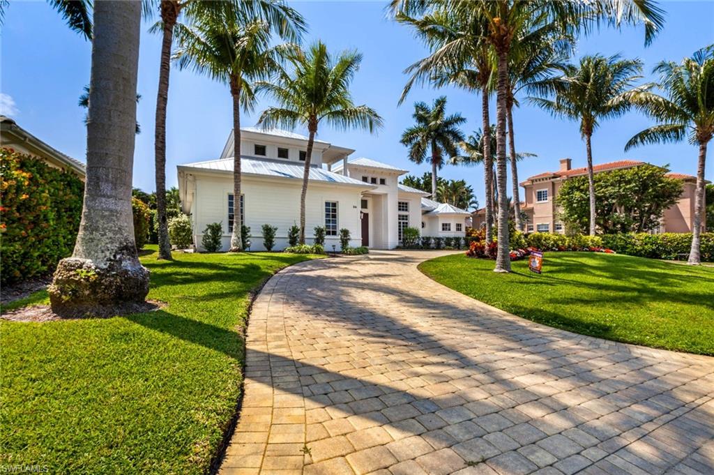 a front view of multi story residential apartment building with yard and green space