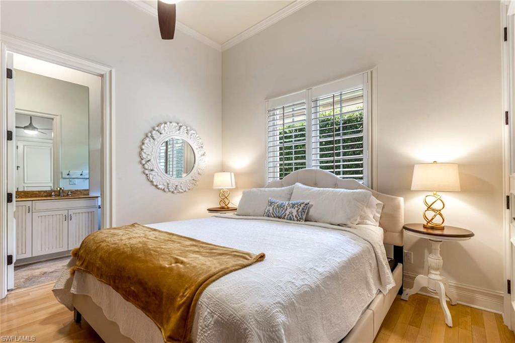 516 Portside Drive Naples, FL 34103 - Photo 11 of 33 a bedroom with a large bed and a chandelier
