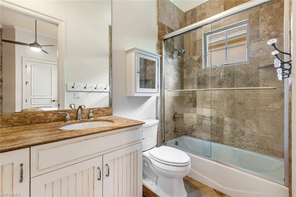 516 Portside Drive Naples, FL 34103 - Photo 12 of 33 a bathroom with a granite countertop sink toilet and shower