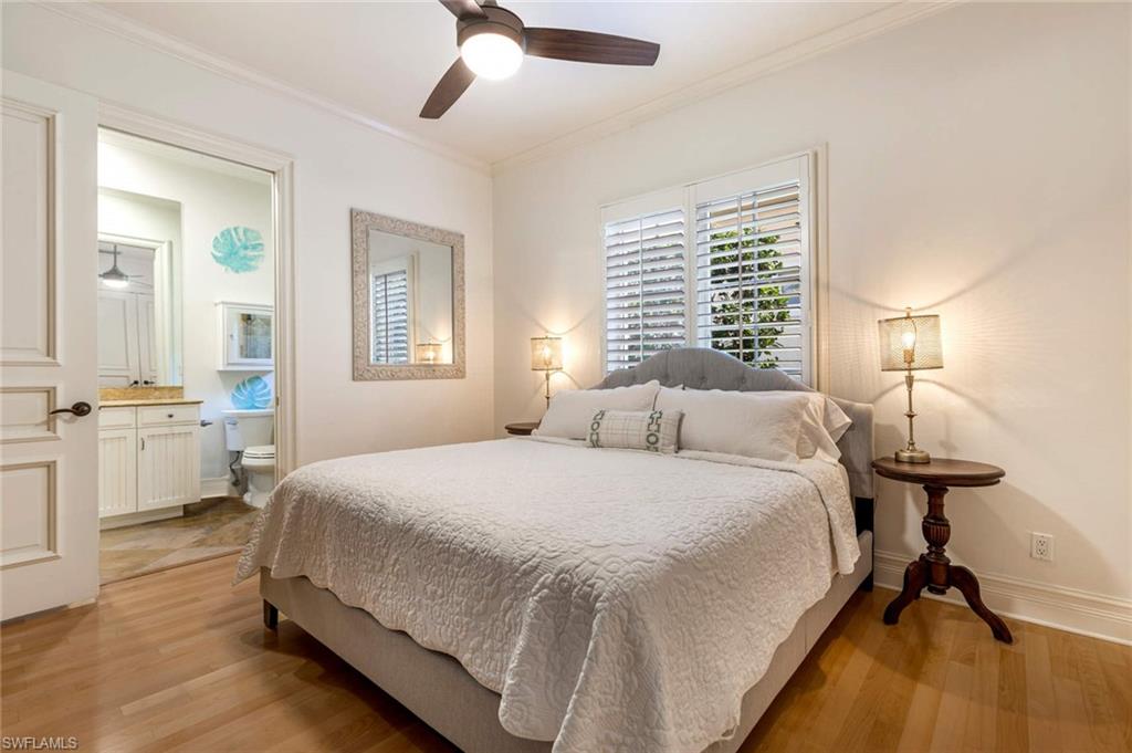 516 Portside Drive Naples, FL 34103 - Photo 13 of 33 a bedroom with a bed and a table with mirror