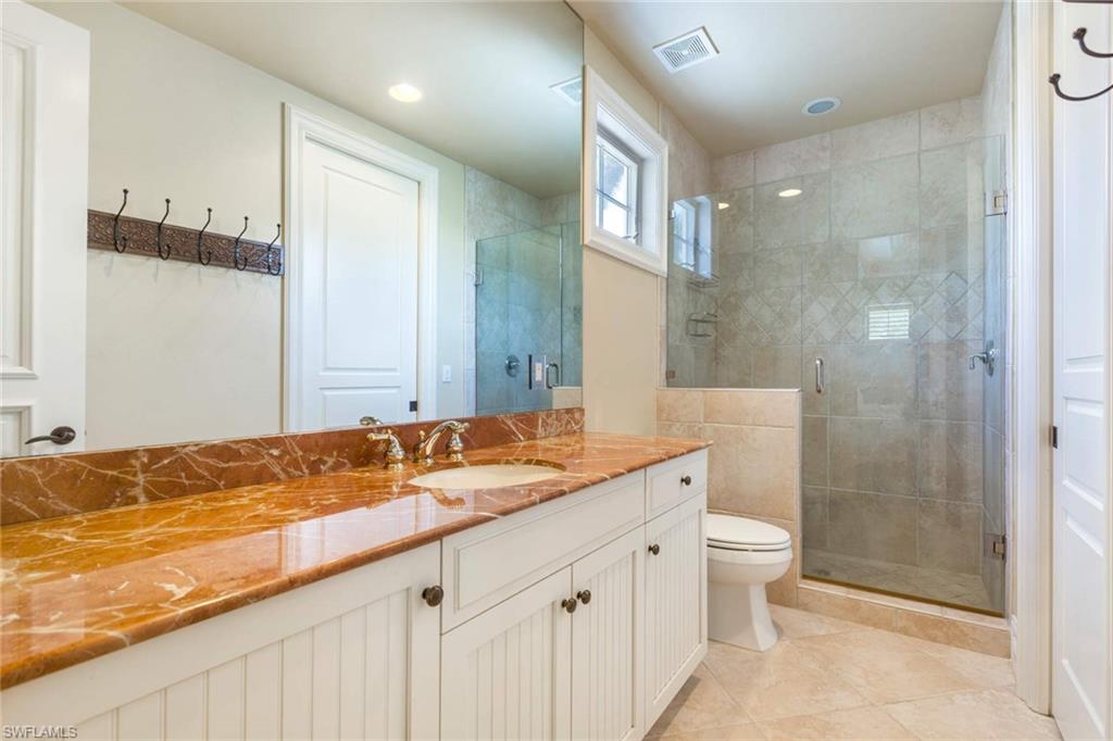 516 Portside Drive Naples, FL 34103 - Photo 28 of 33 a bathroom with a granite countertop sink and a mirror