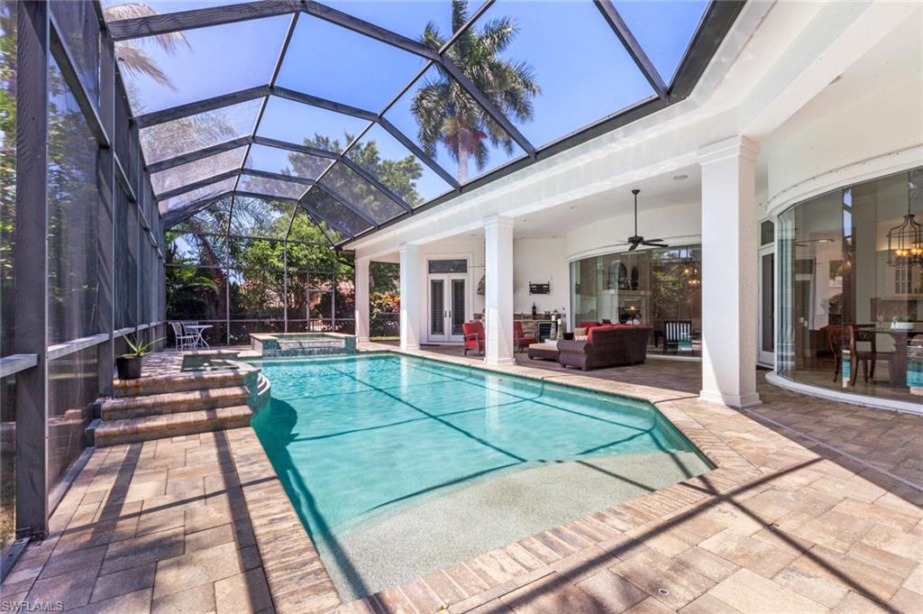516 Portside Drive Naples, FL 34103 - Photo 31 of 33 a view of a patio with dining table and chairs with a small yard