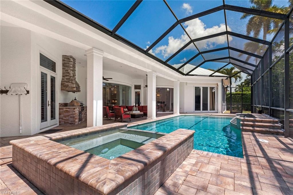 516 Portside Drive Naples, FL 34103 - Photo 32 of 33 a view of a backyard with table and chairs under an umbrella