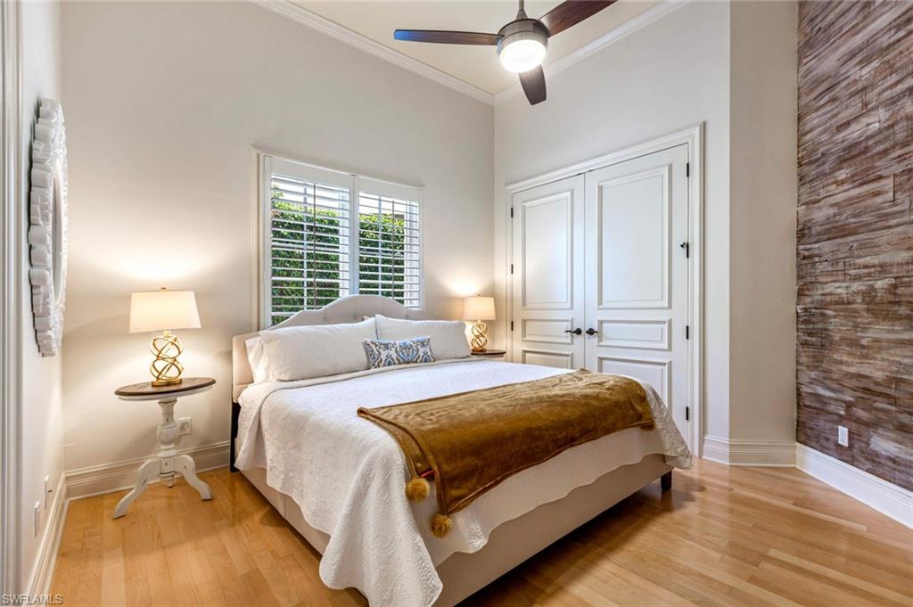 516 Portside Drive Naples, FL 34103 - Photo 10 of 33 a bedroom with a bed and wooden floor