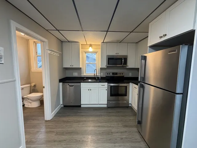 a kitchen with a refrigerator a stove top oven a sink and dishwasher
