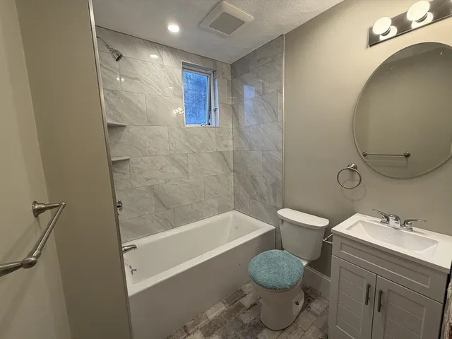 a bathroom with a granite countertop toilet sink and shower