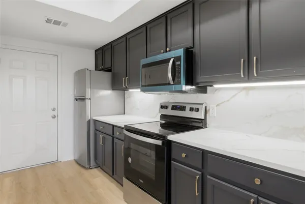 a kitchen with a sink stove and microwave