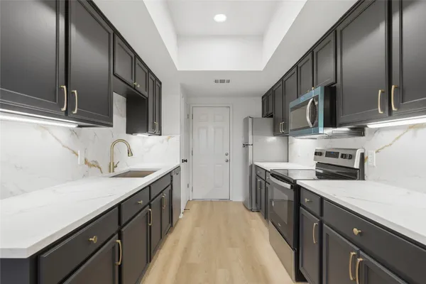 a kitchen with stainless steel appliances granite countertop a sink stove and refrigerator