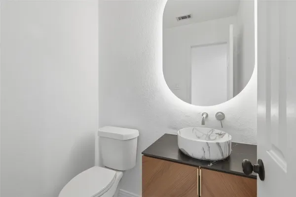 a bathroom with a toilet sink and mirror