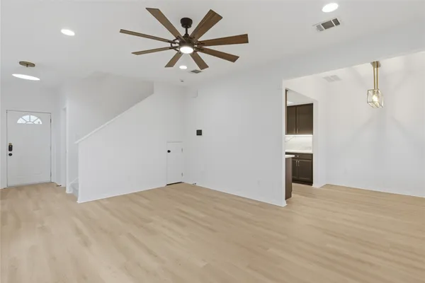 an empty room with fan and windows