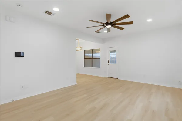 an empty room with closet and windows