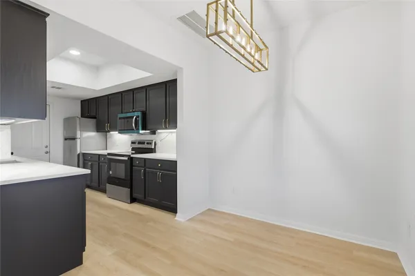 a kitchen with stainless steel appliances granite countertop a sink a stove a refrigerator and cabinets