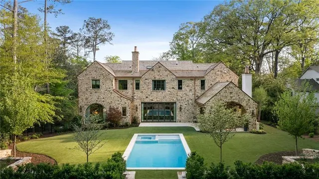a view of a white house with a yard and potted plants