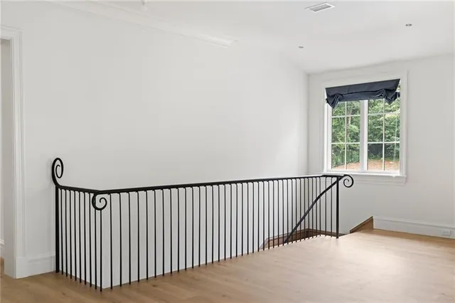 a view of a white house next to a yard with big trees