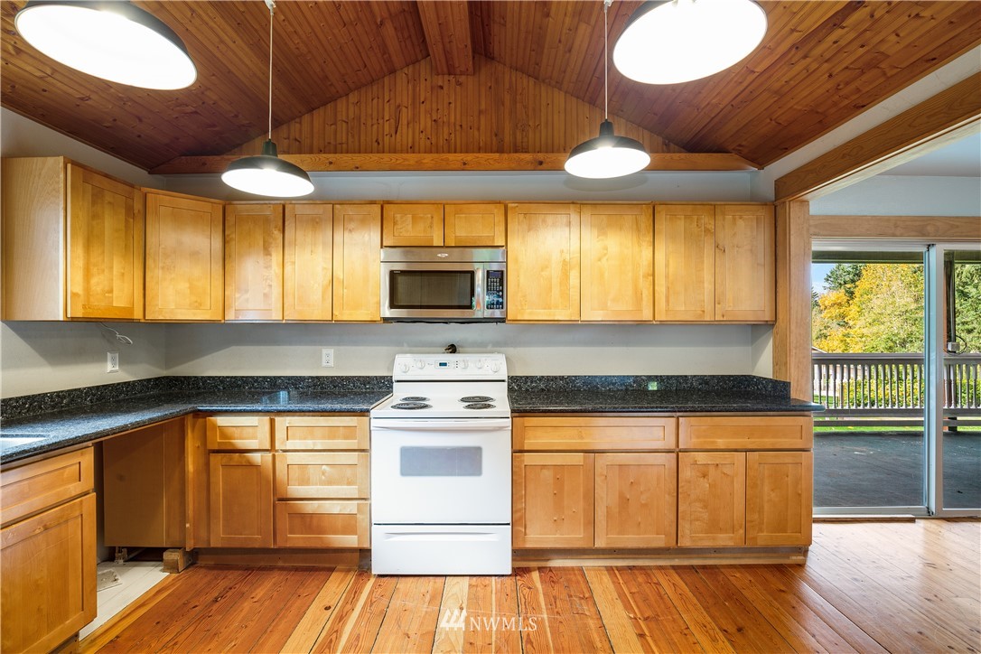 17510 Southeast 121st Place Renton, WA 98059 - Photo 13 of 40 a kitchen with stainless steel appliances granite countertop a stove a sink and a microwave