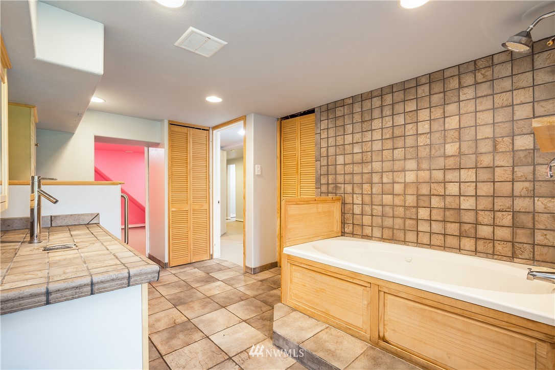 17510 Southeast 121st Place Renton, WA 98059 - Photo 26 of 40 a bathroom with a granite countertop bathtub next to a shower and a sink