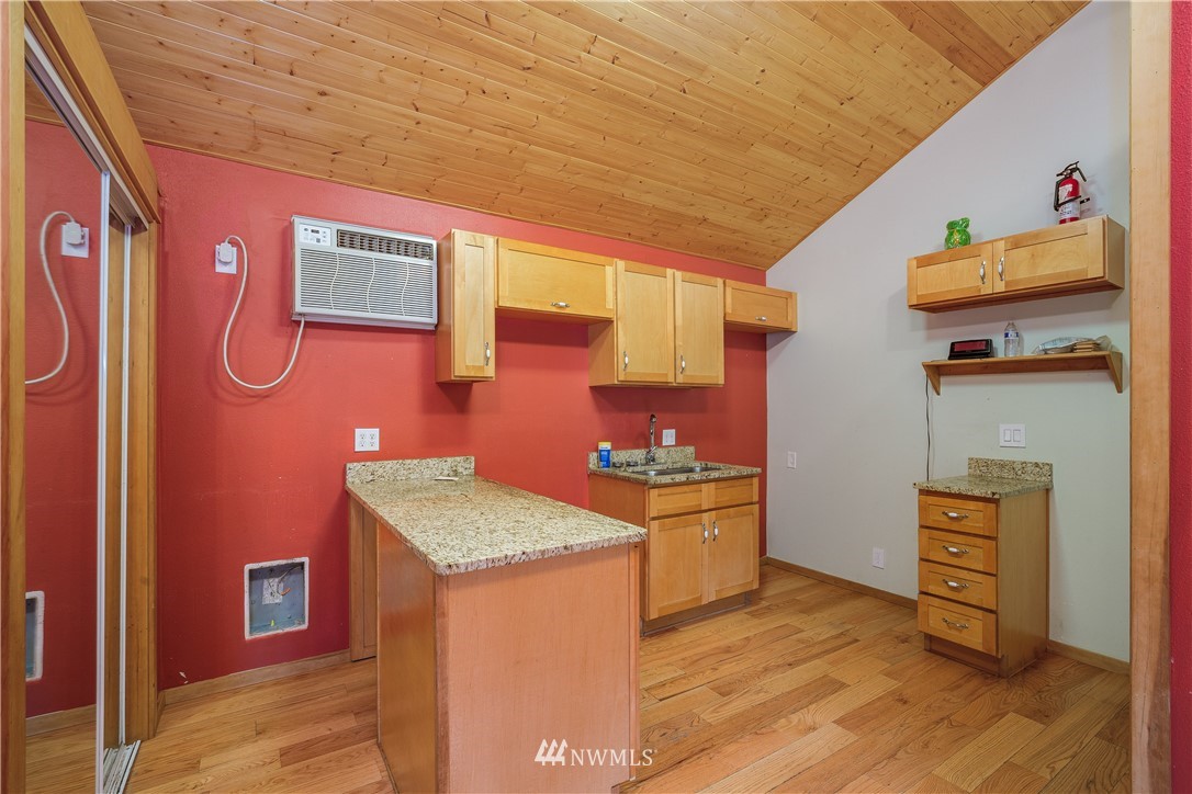 17510 Southeast 121st Place Renton, WA 98059 - Photo 30 of 40 a kitchen with granite countertop cabinets and wooden floor