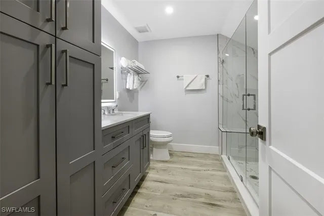 a bathroom with a double vanity sink toilet and shower