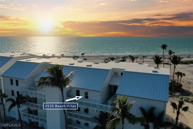 an aerial view of a building and ocean view