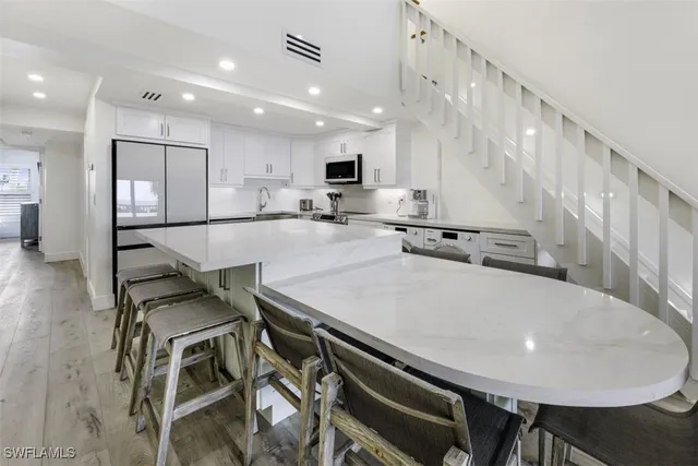 a large kitchen with kitchen island a stove a table and chairs