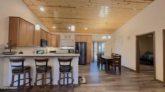 a kitchen with a dining table chairs and wooden floor