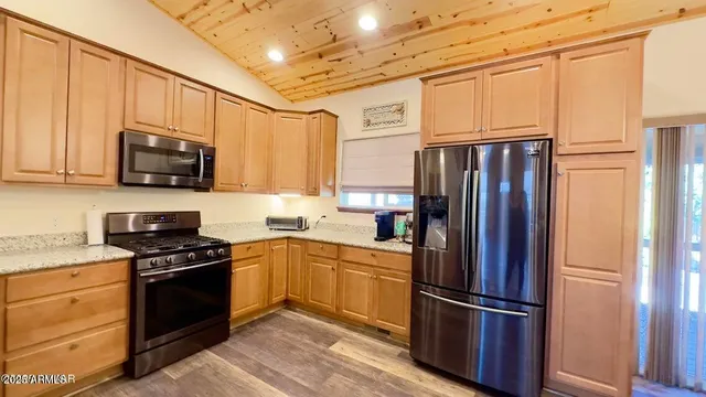 a kitchen with stainless steel appliances granite countertop a refrigerator stove and sink