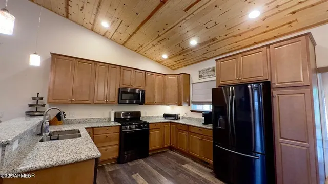 a kitchen with granite countertop stainless steel appliances and refrigerator