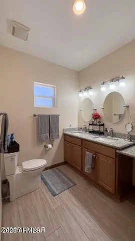 a large bathroom with a granite countertop toilet a sink and a bathtub