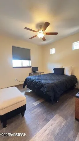 a bedroom with a bed ceiling fan and a window