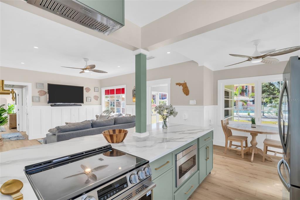 16613 Gulf Boulevard North Redington Beach, FL 33708 - Photo 12 of 51 a living room with stainless steel appliances furniture a rug and a flat screen tv