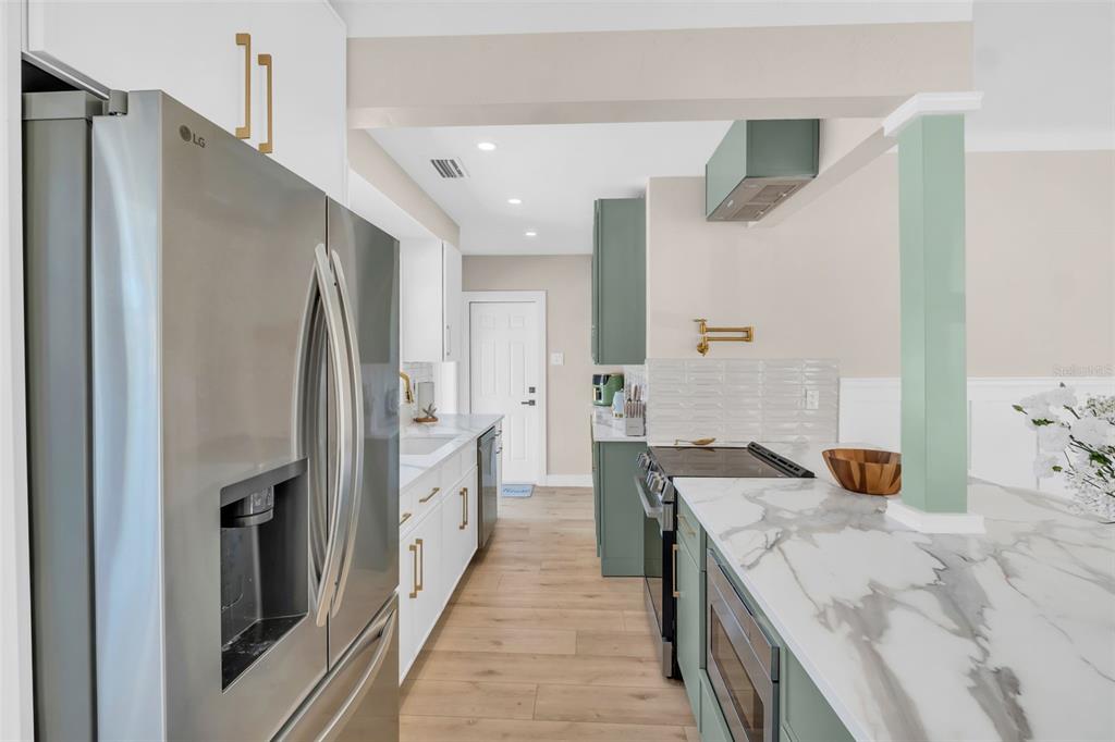 16613 Gulf Boulevard North Redington Beach, FL 33708 - Photo 13 of 51 a large kitchen with stainless steel appliances granite countertop a refrigerator and a sink